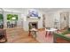 Bright living room featuring hardwood floors, fireplace, and open view to dining area and kitchen at 2410 Huron St, Durham, NC 27707