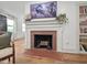 Living room featuring a brick fireplace, hardwood floors and built in bookshelves at 2410 Huron St, Durham, NC 27707