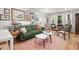 Bright living room featuring hardwood floors, stylish furniture, and large windows with white curtains at 2410 Huron St, Durham, NC 27707