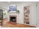 Bright living room with hardwood floors, brick fireplace, and a built-in bookcase at 2410 Huron St, Durham, NC 27707