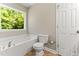 Bathroom features a soaking tub, toilet, and window at 2555 Winding Creek Ln, Franklinton, NC 27525