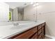 Bathroom vanity with double sinks, wood cabinets, mirror, and tile floors at 2555 Winding Creek Ln, Franklinton, NC 27525
