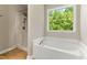 Bright bathroom featuring a soaking tub with window and separate shower at 2555 Winding Creek Ln, Franklinton, NC 27525
