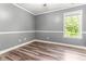 Neutral bedroom with wood-look floors, natural light, and modern trim at 2555 Winding Creek Ln, Franklinton, NC 27525