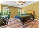 Bedroom featuring two windows, modern ceiling fan, and wood-look flooring at 2555 Winding Creek Ln, Franklinton, NC 27525