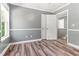 Neutral bedroom with wood-look floors, natural light, and paneled doors at 2555 Winding Creek Ln, Franklinton, NC 27525