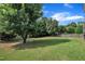 Expansive backyard featuring a lush green lawn, mature trees, and a fenced perimeter at 2605 Bloomsberry Ridge Dr, Fuquay Varina, NC 27526
