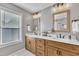 Bathroom featuring double sink vanity with granite countertop, modern fixtures, and bright natural light at 2605 Bloomsberry Ridge Dr, Fuquay Varina, NC 27526