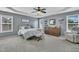 Cozy bedroom featuring plush carpet, natural light, ceiling fan, and neutral gray color palette at 2605 Bloomsberry Ridge Dr, Fuquay Varina, NC 27526