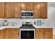 Modern kitchen featuring stainless steel appliances, white countertops, and wooden cabinets at 2605 Bloomsberry Ridge Dr, Fuquay Varina, NC 27526