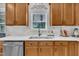 Kitchen featuring wooden cabinetry, stainless steel dishwasher, and white subway tile backsplash at 2605 Bloomsberry Ridge Dr, Fuquay Varina, NC 27526