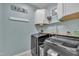 Well-lit laundry room featuring modern washer and dryer units, storage cabinets and light blue walls at 2605 Bloomsberry Ridge Dr, Fuquay Varina, NC 27526