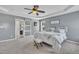 Well-lit bedroom featuring carpet, ceiling fan, access to the ensuite, and gray walls at 2605 Bloomsberry Ridge Dr, Fuquay Varina, NC 27526