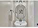 Stylish powder room with an oval mirror, modern lighting, and a white pedestal sink at 2605 Bloomsberry Ridge Dr, Fuquay Varina, NC 27526