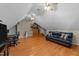 Large bonus room featuring hardwood floors, multiple ceiling fans, and a leather sofa at 2813 Greenridge View Ln, Zebulon, NC 27597
