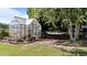 Lovely greenhouse with glass panes and a brick foundation, with a hammock nearby to enjoy the garden at 2813 Greenridge View Ln, Zebulon, NC 27597