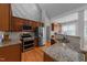 Gourmet kitchen with wood cabinetry, granite counters, stainless appliances, and stylish backsplash at 2813 Greenridge View Ln, Zebulon, NC 27597