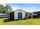 Quaint outbuilding features blue double doors, a weathervane, and a covered area for outdoor work or storage at 2813 Greenridge View Ln, Zebulon, NC 27597