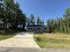 Inviting single-story home with a long driveway and a beautifully landscaped front yard at 299 Starry Sky Dr, Benson, NC 27504