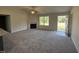 Bright living room with a fireplace, large windows, and an open floor plan at 299 Starry Sky Dr, Benson, NC 27504