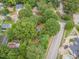 Aerial view showcasing a neighborhood with mature trees and road access to the property, with a pool at 301 N King Charles Rd, Raleigh, NC 27610