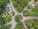 Aerial shot of neighborhood with mature trees, roundabout and pool views at 301 N King Charles Rd, Raleigh, NC 27610