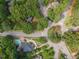 An aerial shot of the neighborhood highlighting mature trees, a roundabout, and a swimming pool at 301 N King Charles Rd, Raleigh, NC 27610