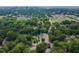 Aerial view shows home among lush trees in a neighborhood with a cityscape in the background at 301 N King Charles Rd, Raleigh, NC 27610
