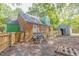 Backyard view of a brick home with a fenced yard, shed, and some construction materials at 301 N King Charles Rd, Raleigh, NC 27610
