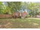 Attractive single-Gathering home with a brick facade, green siding, a manicured lawn and wooden fence at 301 N King Charles Rd, Raleigh, NC 27610