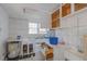 Dated kitchen featuring white tile walls, open cabinets, and a sink, requiring a remodel at 301 N King Charles Rd, Raleigh, NC 27610