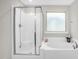 Clean bathroom featuring glass shower and soaking tub with large window for natural light at 304 Garden Walk Dr, Durham, NC 27703