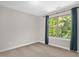 Bedroom featuring a large window with wooded views, neutral walls and carpet at 304 Garden Walk Dr, Durham, NC 27703