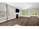 Comfortable living room featuring hardwood floors, large windows, and a sleek fireplace, perfect for relaxation at 304 Garden Walk Dr, Durham, NC 27703