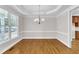 The dining room features a decorative light fixture, a large window and hardwood floors at 305 Avent Meadows Ln, Holly Springs, NC 27540