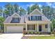 Charming home with a manicured lawn and a two-car garage, nestled among tall trees at 305 Avent Meadows Ln, Holly Springs, NC 27540