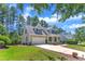 Inviting home with a lush lawn, mature trees, and an attached two-car garage at 305 Avent Meadows Ln, Holly Springs, NC 27540