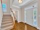 Inviting foyer with hardwood floors, carpeted stairs, and a glimpse of a half-bathroom at 305 Avent Meadows Ln, Holly Springs, NC 27540