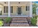 Welcoming front porch with brick steps, white columns, and a traditional dark-colored front door at 305 Avent Meadows Ln, Holly Springs, NC 27540
