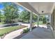 Spacious covered front porch with white columns, brick accents, and a view of the landscaped yard at 305 Avent Meadows Ln, Holly Springs, NC 27540