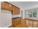 Kitchen with wood cabinets, black countertops, and hardwood flooring at 305 Avent Meadows Ln, Holly Springs, NC 27540