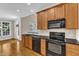 Traditional kitchen with wood cabinets, black appliances, and hardwood flooring at 305 Avent Meadows Ln, Holly Springs, NC 27540