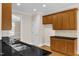 Kitchen with stainless steel sink, wood cabinets, and black countertops at 305 Avent Meadows Ln, Holly Springs, NC 27540