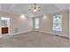 Spacious main bedroom featuring a tray ceiling, carpeted floors, and two windows at 305 Avent Meadows Ln, Holly Springs, NC 27540
