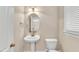 This powder room offers a pedestal sink, a decorative mirror, and natural light from the window at 305 Avent Meadows Ln, Holly Springs, NC 27540