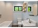 Well-lit bathroom featuring classic fixtures, white tile, and ample natural light from a window at 3213 Mid Pines Rd, Raleigh, NC 27606