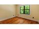 Cozy bedroom with hardwood floors and a window view of lush trees outside at 3213 Mid Pines Rd, Raleigh, NC 27606