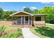 Charming bungalow with a screened-in porch, yellow siding, and landscaped front yard at 3213 Mid Pines Rd, Raleigh, NC 27606