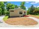 Charming home with red door and surrounded by trees and gravel driveway at 3213 Mid Pines Rd, Raleigh, NC 27606