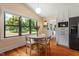 Eat-in kitchen featuring bright windows offering lawn views, white cabinets, and stainless appliances at 3213 Mid Pines Rd, Raleigh, NC 27606